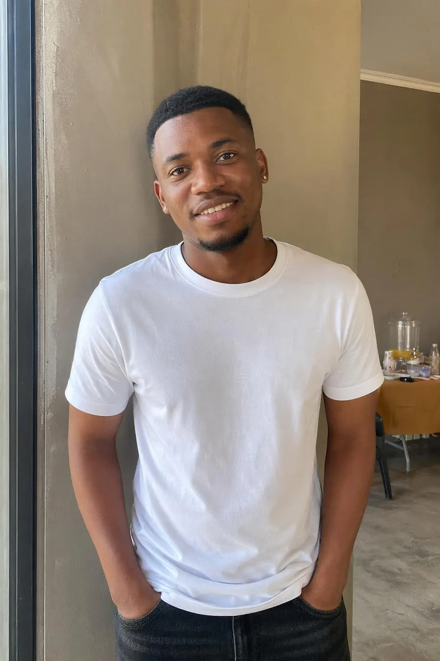 An ordinary phone snapshot of the same guest in a white t-shirt against a plain wall.